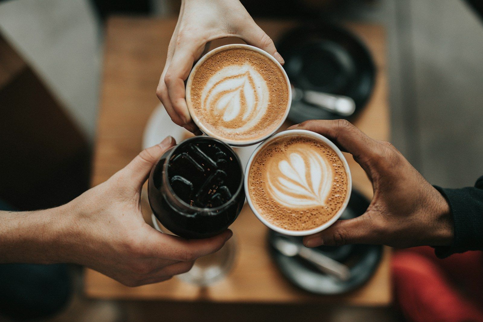 A coffee cup beside a laptop on a cafe table